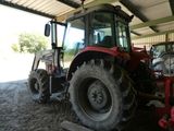 un tracteur rouge garé dans une grange