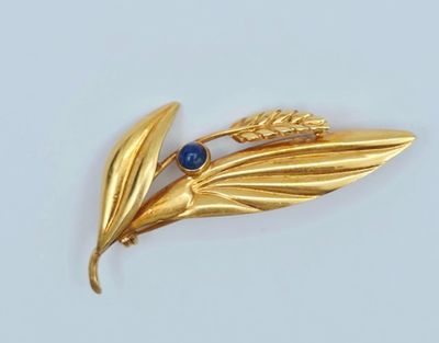 une image représentant une broche en or ornée d'une pierre bleue au centre