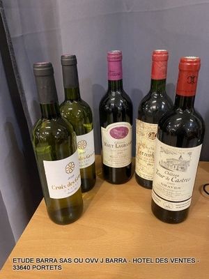 several bottles of wine are lined up on a wooden table