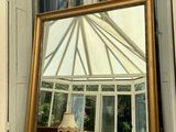 a mirror sitting on a window sill in front of a window
