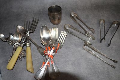 un grand nombre de cuillères et de fourchettes disposées sur la table