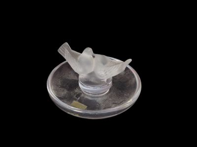 un oiseau perché sur une assiette en verre