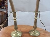 pair of brass candles on a wooden table in a store