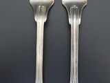 two forks that are sitting next to each other on a table
