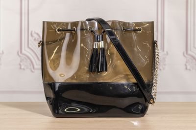 black and gold handbag with tassels on a wooden table