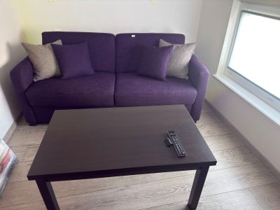a purple couch and a black coffee table in a living room