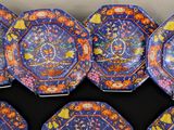 six blue and orange plates with designs on them sitting on a table