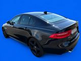 the rear end of a black car on a blue background