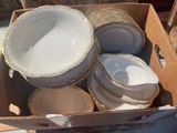 a cardboard box filled with plates and bowls in it
