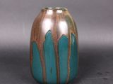 a blue and brown vase sitting on a gray surface