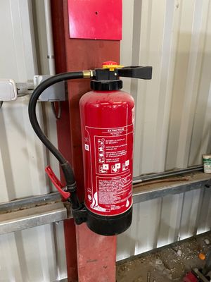 un extincteur fixé à un poteau dans un garage