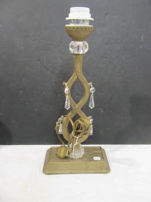a gold candle holder with a glass candle on it