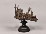 une image représentant une sculpture en bronze représentant une couronne posée sur un socle