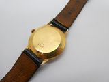 une image d'un gros plan d'une montre-bracelet sur une surface blanche