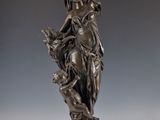 statue en bronze d'une femme tenant un oiseau sur un piédestal