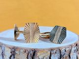 a close up of a pair of cuff rings on a tree stump