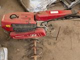 une machine rouge posée par terre à côté d'un tas de sacs