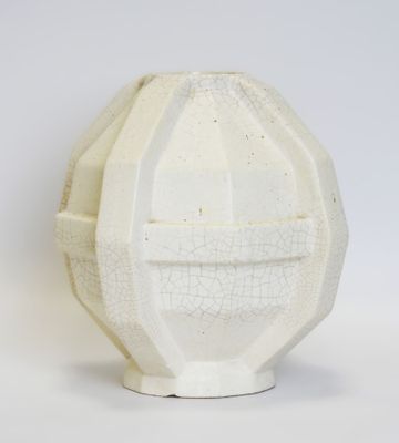 a white vase with a face on it on a white surface