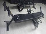 un banc noir posé à même le sol, à côté de deux appareils de musculation