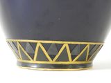 a black bowl with a gold decoration on it