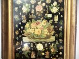 painting of a basket of flowers in a gold frame on a black background
