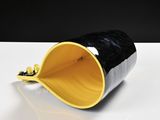 a black and yellow cup with a gold handle