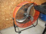 un ventilateur posé par terre à côté d'une table