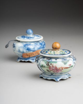 two small blue and white jars with lids and a wooden lid