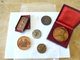 une petite boîte contenant des pièces de monnaie et une médaille, posée sur une table