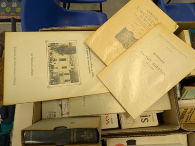 a box full of books sitting on top of a blue chair