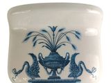 a blue and white container with a bird and a plant on it