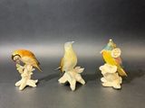 trois figurines d'oiseaux posées les unes à côté des autres sur une table