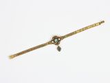 une photo d'un bracelet en or orné d'une pierre verte