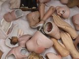 une boîte remplie de têtes de poupées et d'autres objets posée sur une table