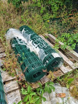 de nombreux rouleaux de plastique posés sur une palette dans l'herbe