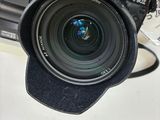 a person holding a camera with a lens attached to it