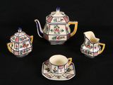 four pieces of porcelain tea set on a black background