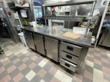 une grande cuisine équipée d'appareils électroménagers en inox et de plans de travail