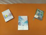 trois livres posés sur un lit recouvert de draps orange