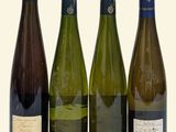 four bottles of wine are lined up in a row on a white background