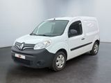 La camionnette blanche est garée dans une grande pièce au sol noir.