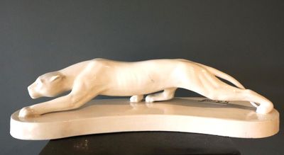statue d'un chat posée sur un socle, sur une surface noire