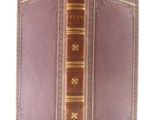 an old book with a brown cover and gold trim