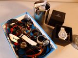 une boîte contenant un assortiment de montres et d'autres objets posée sur une table