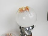 two glass globe lamps on a metal stand against a white background