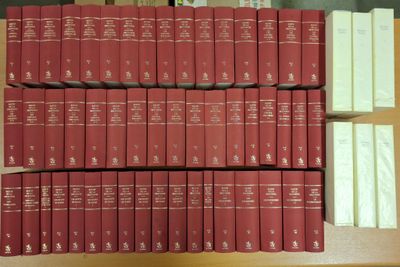 de nombreux livres empilés sur une étagère dans une bibliothèque