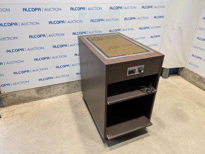 a brown speaker stands in front of a wall with a sign on it