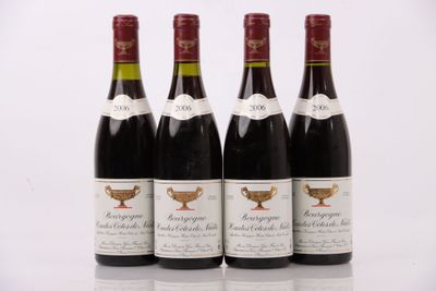 quatre bouteilles de vin sont alignées sur une surface blanche