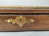 a close up of a wooden box with a gold decoration on it