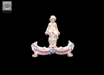 une figurine représentant un garçon dans un bateau, sur fond noir